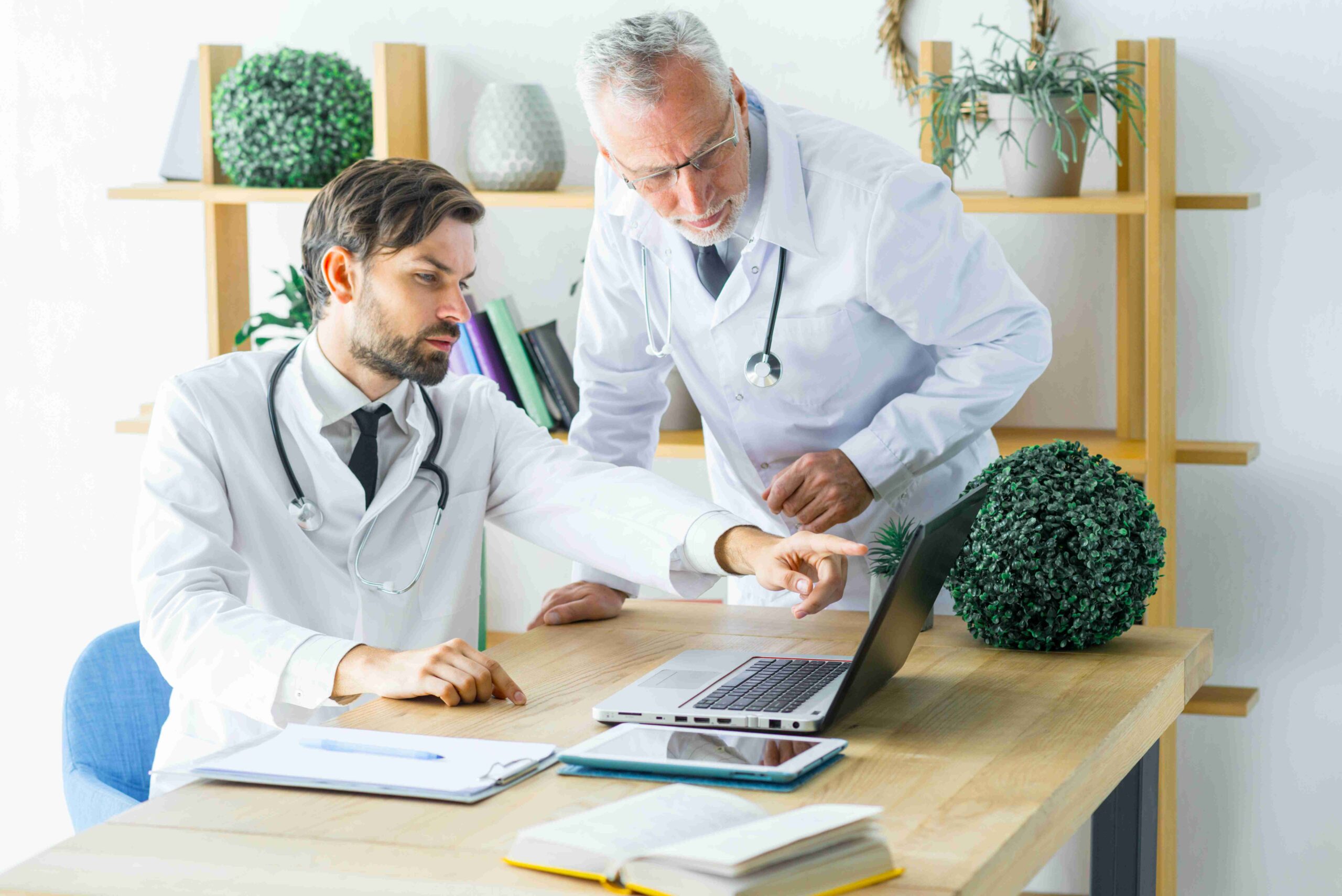 compressed doctors discussing data laptop scaled 1